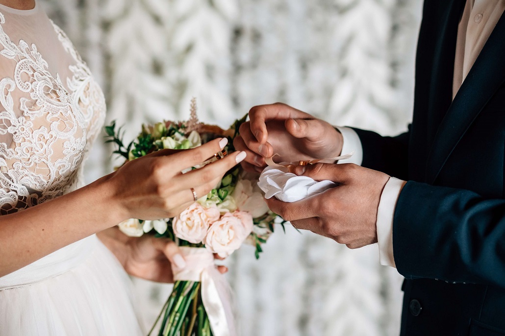 Hochzeitsversicherung Das Brautpaar beim Tausch der Ringe
