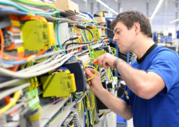 Elektroniker arbeitet an der Verdrahtung in einem Schaltschrank