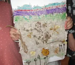 Waldenburger Zukunftshelden - Kindergarten Kuhfelde - Endergebnis Ein Kind zeigt stolz ein neu hergestelltes, bemaltes Papier