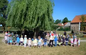 Waldenburger Zukunftshelden – Kita Langerwisch – Draußen unterwegs Kinder und Erzieher stehen im Kreis um einen Baum im Garten der Kita Zwergenhof Langerwisch